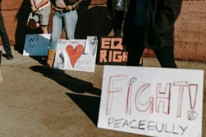 Protesters hold signs advocating for equality and peace during a daytime demonstration.
