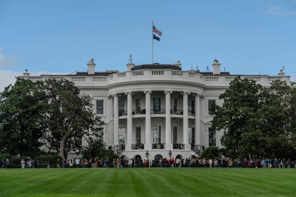 A picturesque view of the White House with the American flag in daylight.