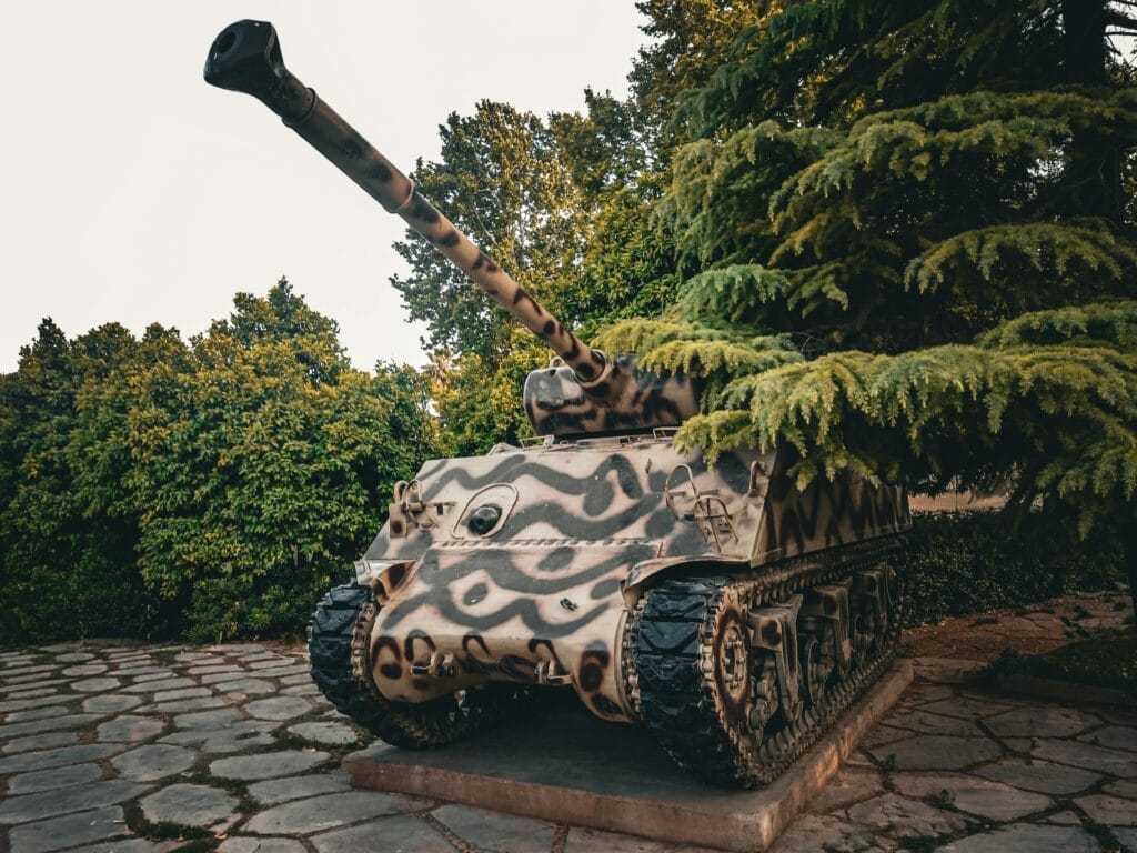 A vintage World War 2 tank displayed at Afif-Abad Garden, Shiraz, Iran, surrounded by lush greenery.